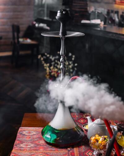 green steaming hookah on the table tea side view